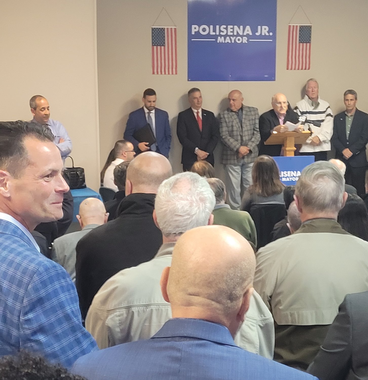 BIG CROWD: Johnston Mayor Joseph M. Polisena introduced his son to an overflow crowd in an empty storefront in Town Hall Plaza. Joe Polisena Jr. announced his candidacy for mayor, in front of friends, family, local politicians and key community representatives.